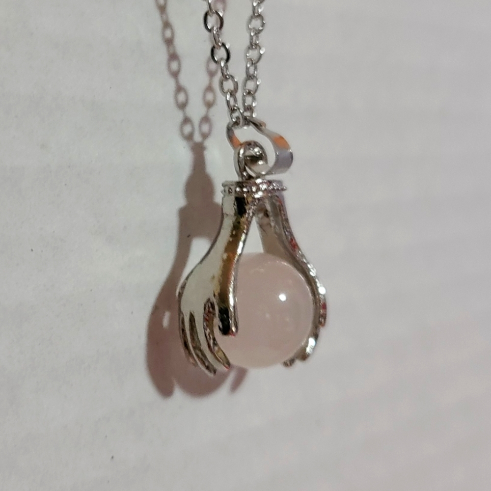 HAND HOLDING THE MOON PENDANT